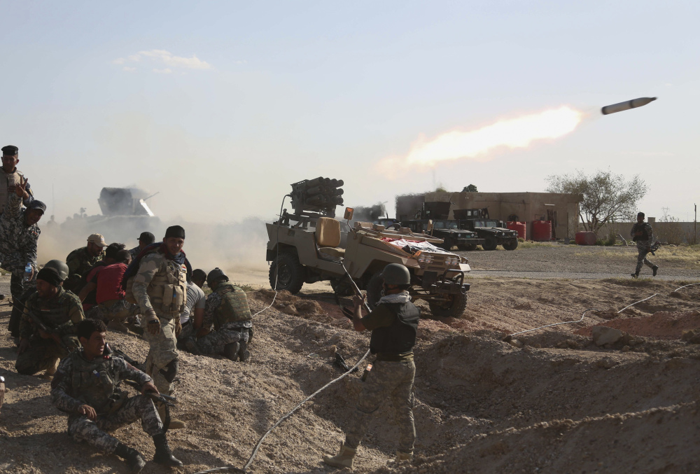 Iraqi security forces launch a rocket toward Islamic State extremist positions during clashes in Tikrit, Iraq, on Thursday. But the largely Iranian-backed forces reacted with fury after coalition planes launched 17 airstrikes on Tikrit during the first wave of attacks.