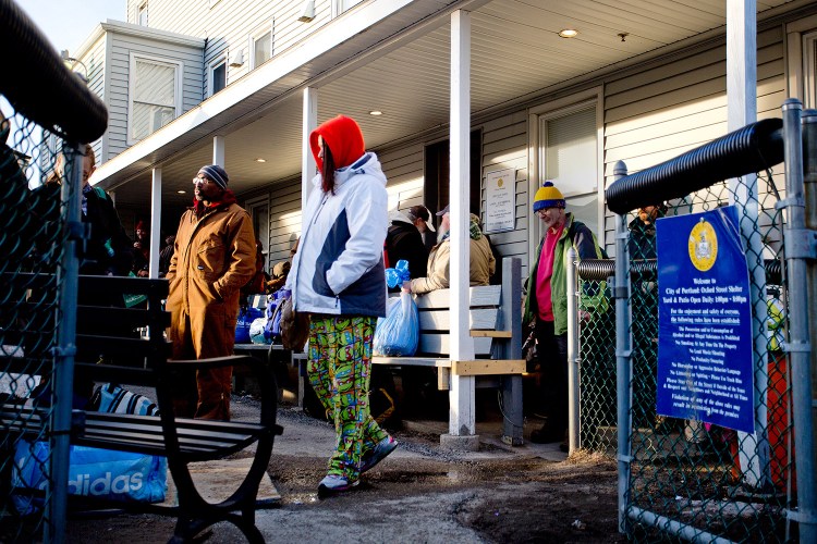 People wait to enter the Oxford Street Shelter in Portland on Monday night. The state provides only $364,000 annually in direct funding to Maine’s 42 shelters, and operators say that’s far from enough.