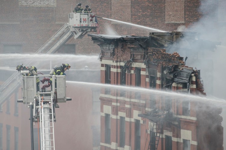 Firefighters spray water on a collapsed building in New York's East Village. The Associated Press