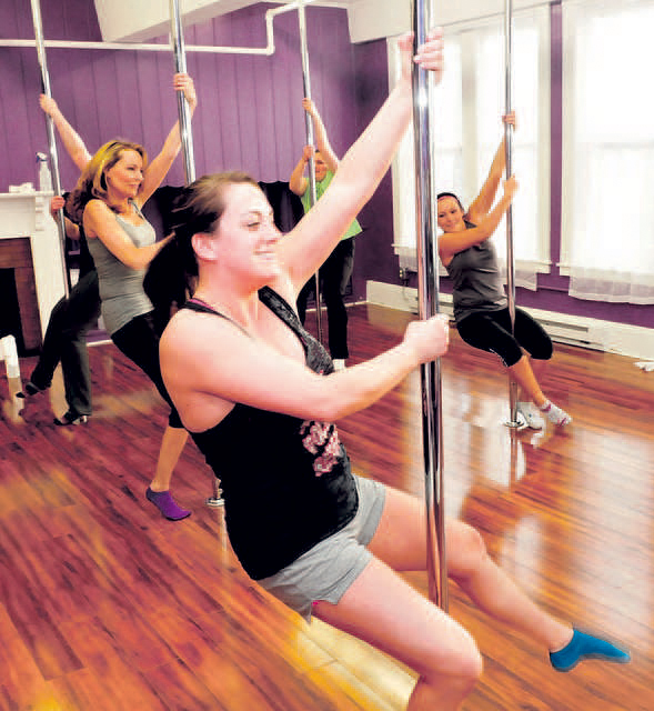 Empower co-owner Heather MacKenzie, front, instructs pole exercise students at the Waterville studio on Wednesday. From left, Penny Davis, Elizabeth Jensen and Sarah Golden take part in the exercise. 