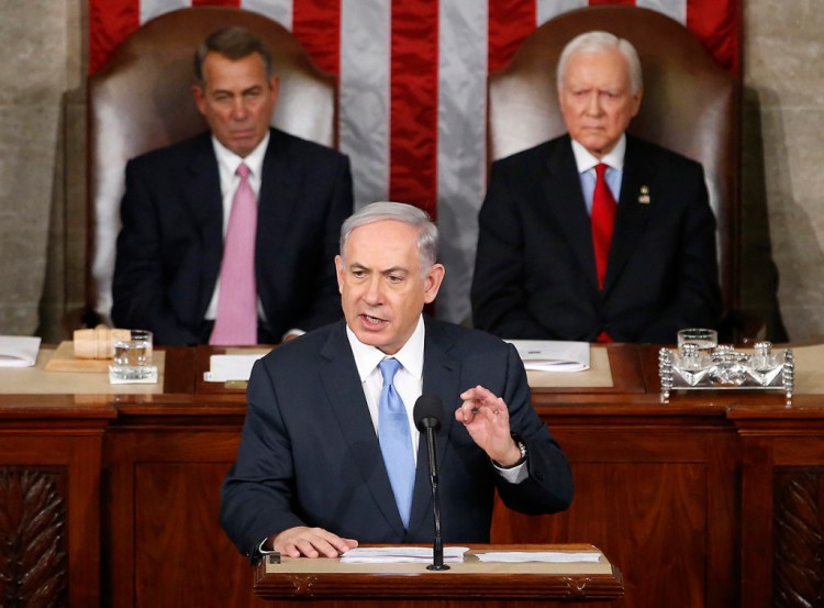 Israeli Prime Minister Benjamin Netanyahu speaks before a joint meeting of Congress on Capitol Hill Tuesday. The world must unite to "stop Iran's march of conquest, subjugation and terror," he said. House Speaker John Boehner of Ohio, left, and Sen. Orrin Hatch, R-Utah, listen. The Associated Press