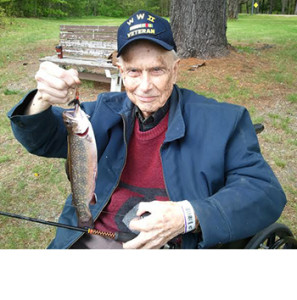 Ezra Smith holds up a brook trout he caught in the Togus pond on May 24, 2015.