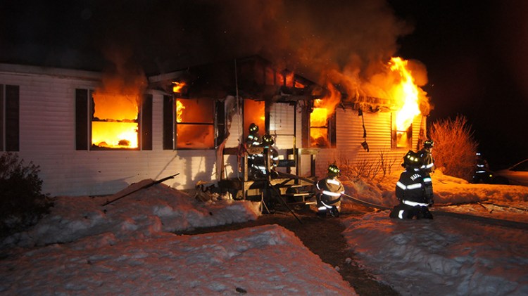 Firefighters battle a mobile home fire on Plains Road in Harrison early Friday morning. The Associated Press