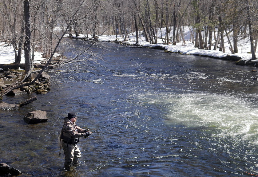 Travis Parlin, of Fairfield, casts a set of nymphs into Cobbosseecontee Stream on Tuesday in Manchester beneath a clear sky. Anglers planning to toss a line into other bodies of water across the state that open Wednesday with the commencement of fishing season will encounter similar conditions, according to the National Weather Service, with plenty of sun and temperatures in the upper 30s.  Parlin said he’s been addicted to connecting flies and fish since he was a freshman in high school.