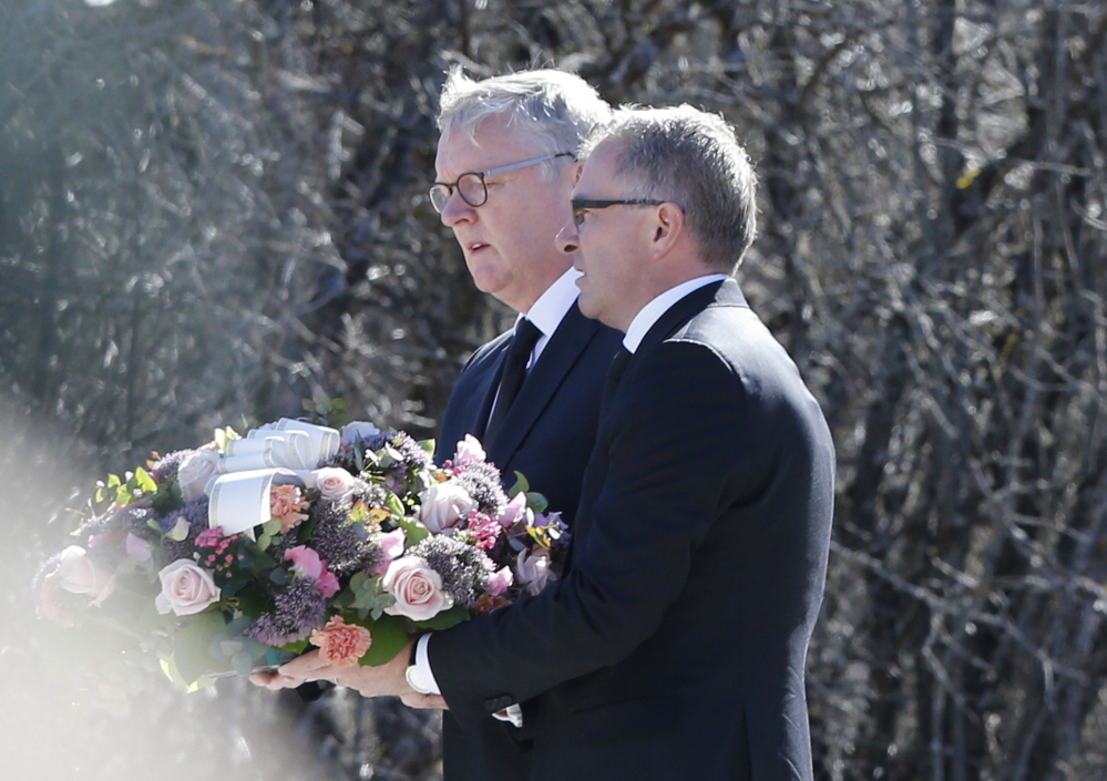 CEOs of Germanwings Thomas Winkelmann, and Lufthansa Carsten Spohr, right,  flowers to a  memorial stone  erected as a monument, set up in memory of the victims  of the Germanwings jet crash, in Le Vernet, France, Wednesday.