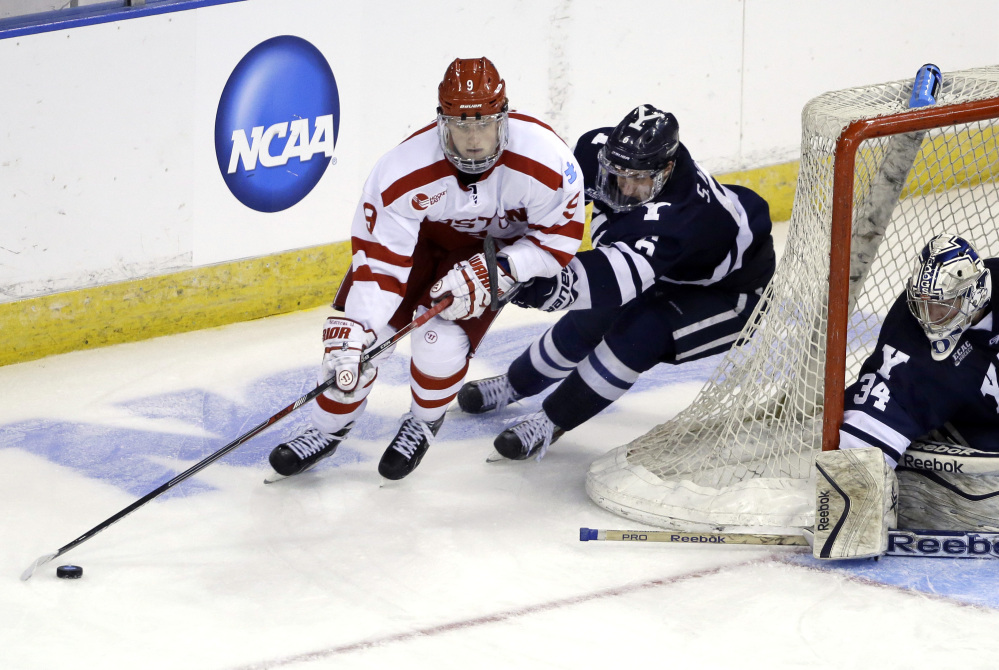 Boston University’s Jack Eichel, front, handles the puck against Yale’s Stu Wilson as goaltender Alex Lyon (34) protects the net in the third period of a regional semifinal game last Friday in Manchester, N.H. Eichel, a freshman, led the nation in scoring this season.