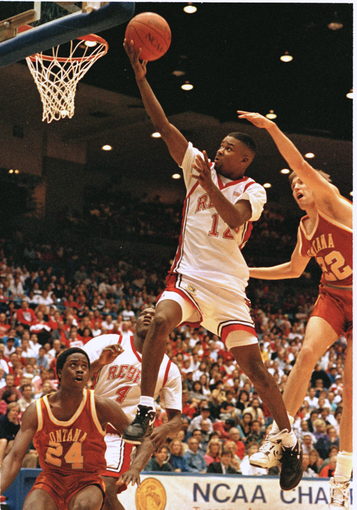 In this March 1991 file photo, UNLV’s guard Anderson Hunt goes past Montana’s Roger Fasting for two points in the final moments of their NCAA first round game in Tucson. Twenty-four years ago, unbeaten UNLV arrived in Indianapolis for a coronation disguised as a Final Four. Now, unbeaten Kentucky is in the same city awaiting its crown. But, as the Rebels discovered, a coronation can fast become an insurrection.