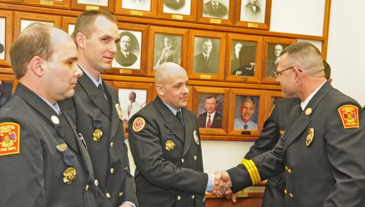 Augusta Fire Lt. Art True, left, and firefighter/paramedics Dan Freeman and Rich Beaudoin received Medals of Valor from Battalion Chief John Bennett for rescuing residents of an apartment complex fire in Gardiner during an Augusta City Council meeting on Thursday in Augusta City Center.