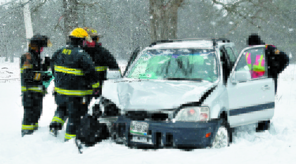 Madison police officer Brett Lowell, right, assists at a car accident in the town in February 2013. Town residents will vote in June on whether to eliminate the town’s police department and instead contract with the Somerset County Sheriff’s Department.