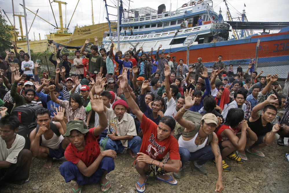 Burmese fishermen at the Aru Islands, Indonesia compound raise their hands as they are asked who among them want to go home.