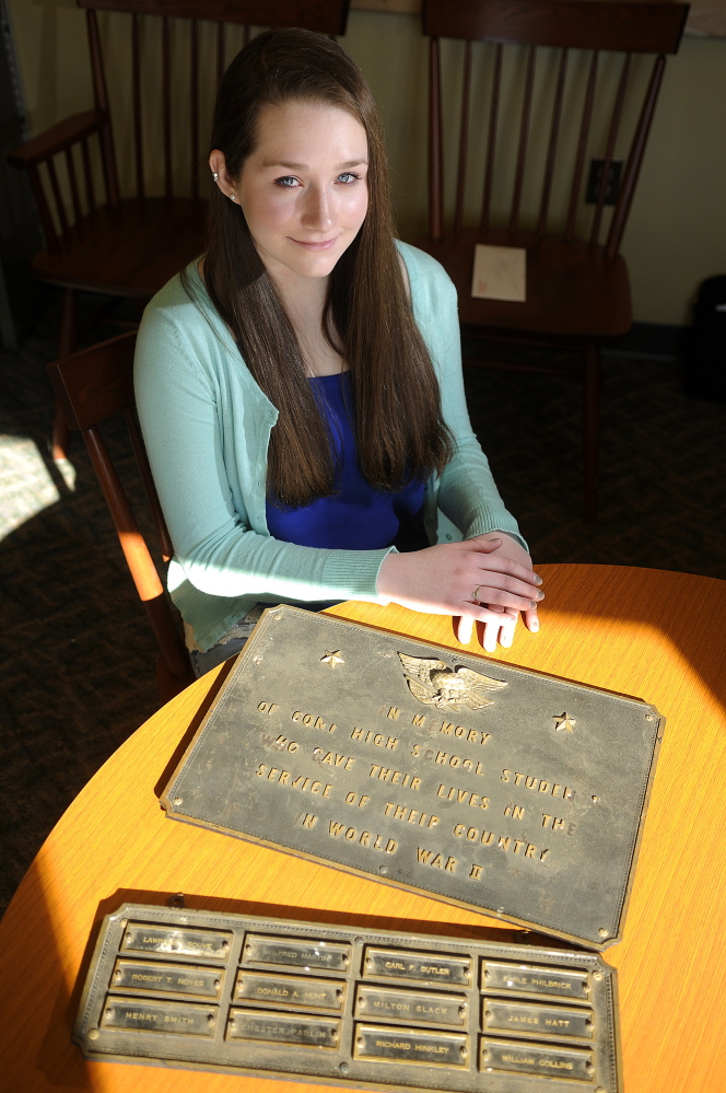 Cony High School senior Kelsey Rohman with a plaque remembering graduates lost in World War II at the Augusta school last week.  Rohman is attempting to have memorials from the old school displayed again at the new school.