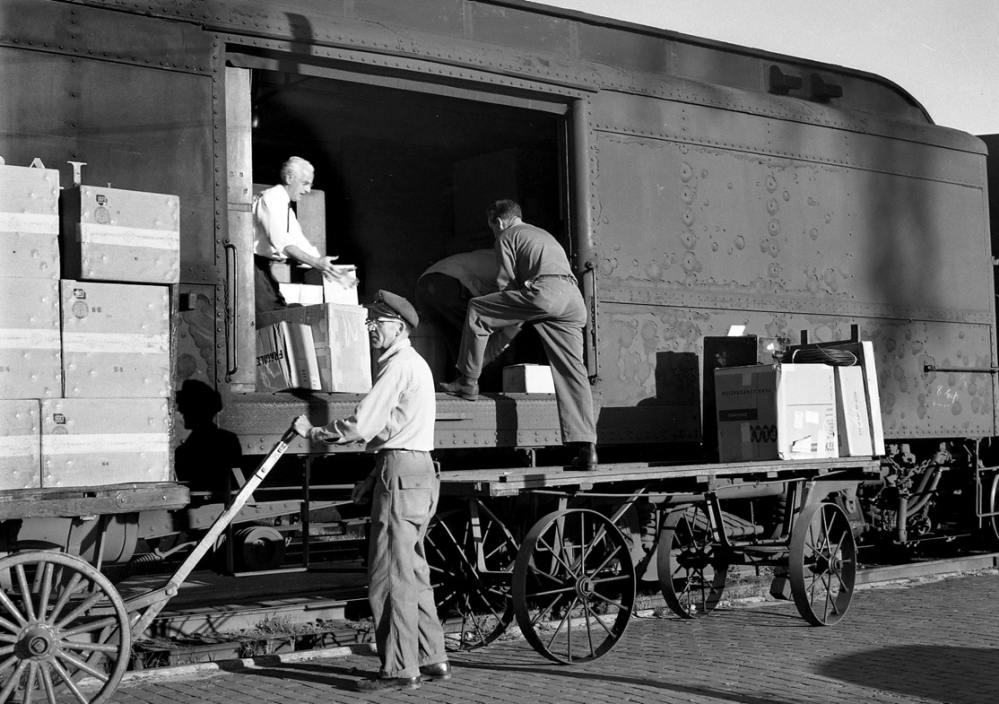 Maine Central Railroad workers load a special “merchandising train” which was launched in September 1960 to carry goods and U.S. Mail after the end of passenger train service through Waterville station.