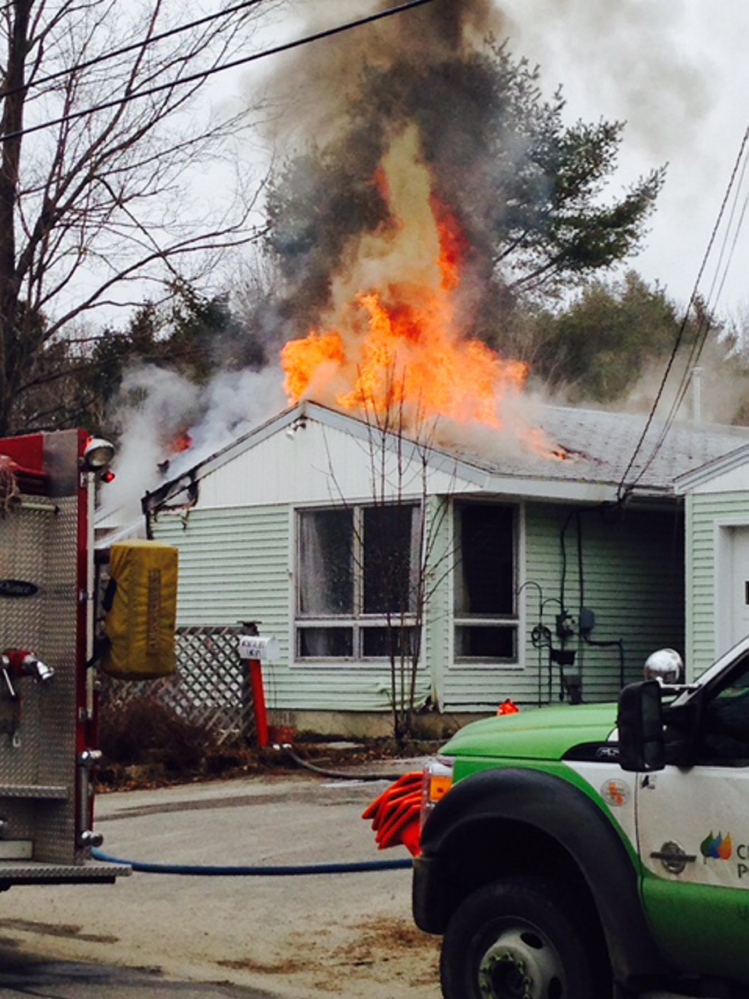 Flames shoot out the roof of a home at 81 Bowman St. in Farmingdale on Wednesday.