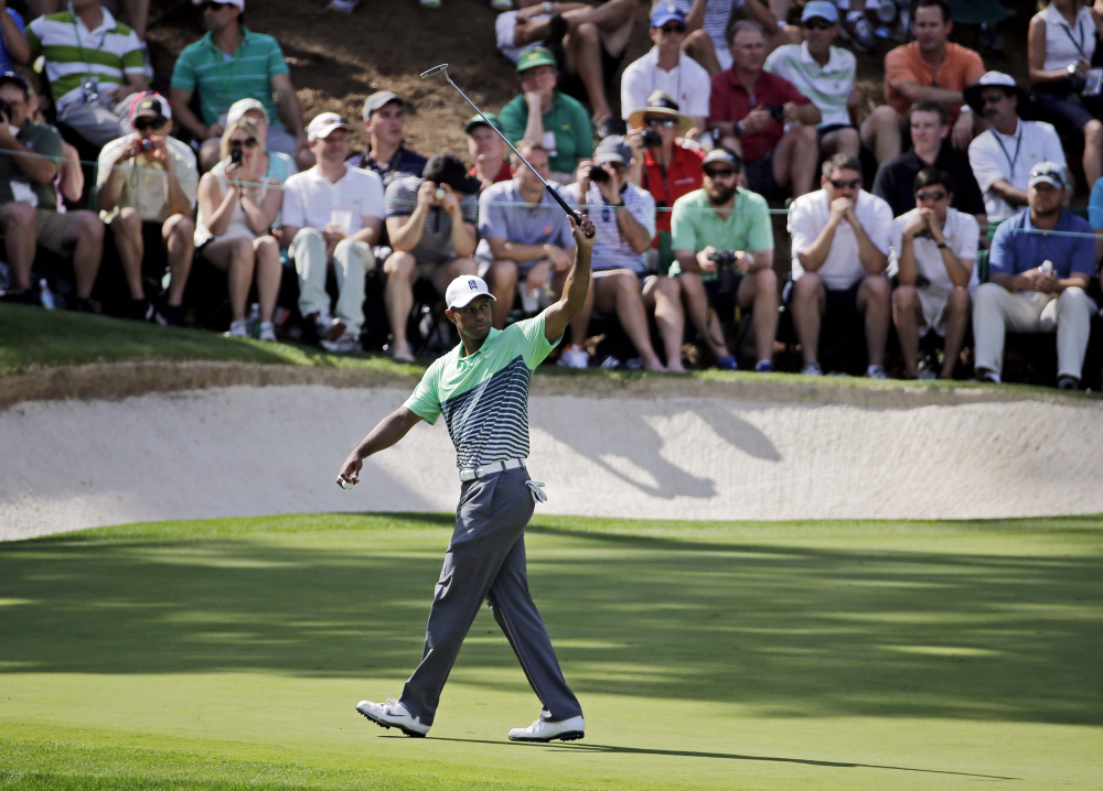 Tiger Woods waves his putter during the Par 3 contest Wednesday at the Masters in Augusta, Ga.
