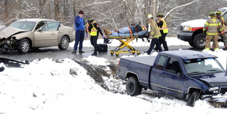 Rescue workers roll a patient to an ambulance at the intersection of Town Farm Road and Winthrop Street in Hallowell Thursday following a two-car collision.