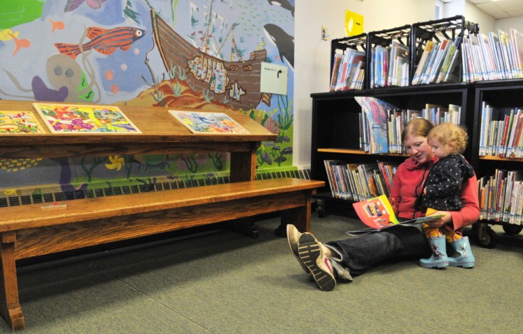 Cassie Boulton reads a picture book to 16-month-old daughter Rosie in the Titcomb Children’s Room on Saturday at Lithgow Library in Augusta. It was the last day before the library closes for renovation. It will temporarily be located in the Ballard Center on the city’s east side.
