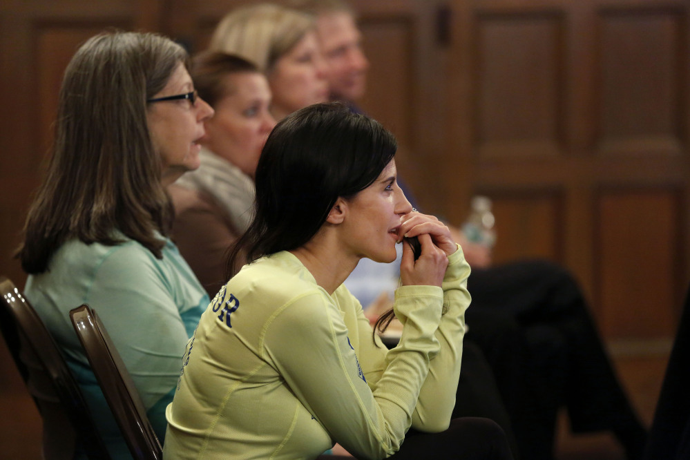 Boston Marathon bombing survivor Lynn Crisci, of Boston, listens during a Massachusetts Resiliency Center meeting at the Old South Church, in Boston. Crisci, who was near an explosion at the finish line of the 2013 Boston Marathon, has suffered from hearing loss, traumatic brain injury, and post-traumatic stress disorder