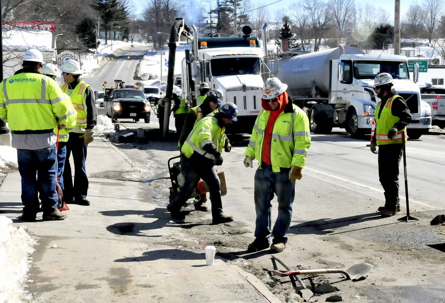 Employees of Summit Natural Gas of Maine and sub-contractors work on the gas pipeline in the center of Norridgewock in this staff file photo. The company has announced job cuts throughout its workforce Friday.