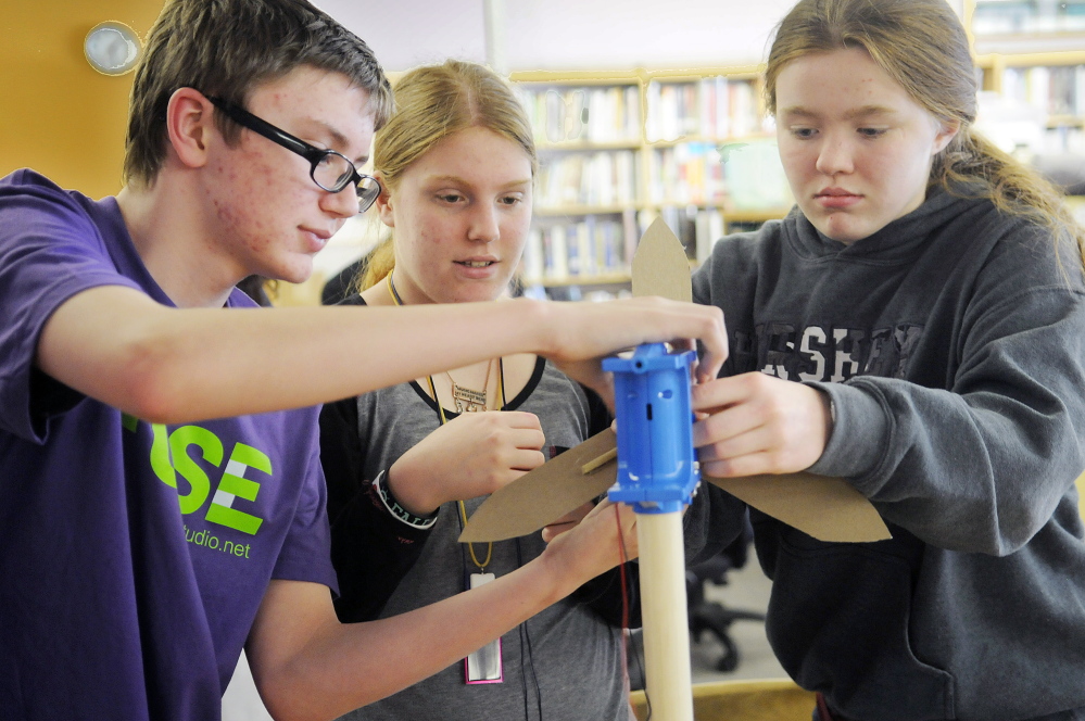Gardiner Area High School students Graesyn Woiccak, left, Alyssa Barnes and Samantha Deans assemble a turbine Monday as part of the green technology program at the school called FUSE. The 14-year-olds explored hands-on challenges inspired by real-world green technology as part of the FUSE program.