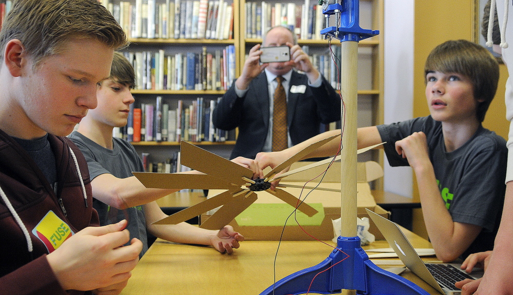 Tom Desjardin, acting commissioner of the Maine Department of Education, photographs Gardiner Area High School students assembling a wind turbine Monday as part of the green technology program at the school called FUSE.