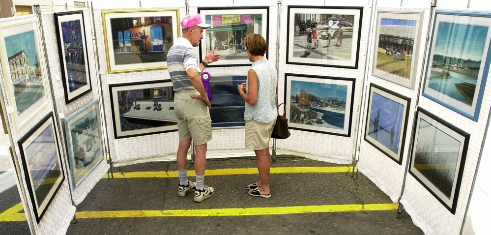 Waterville artist Keith Curtis talks to Ursula Chamberland about one of his pieces at the Arts Fest in 2012.