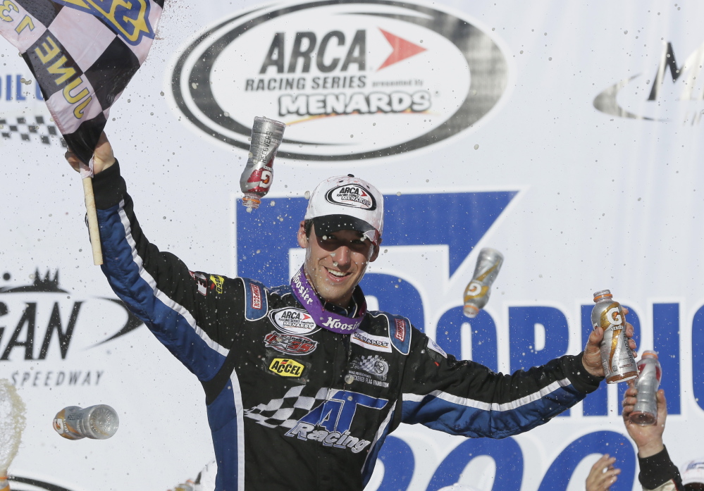 Fort Kent driver Austin Theriault holds the checkered flag after winning the ARCA Corrigan Oil 200 at Michigan International Speedway in Brooklyn, Mich. on June 13, 2014.