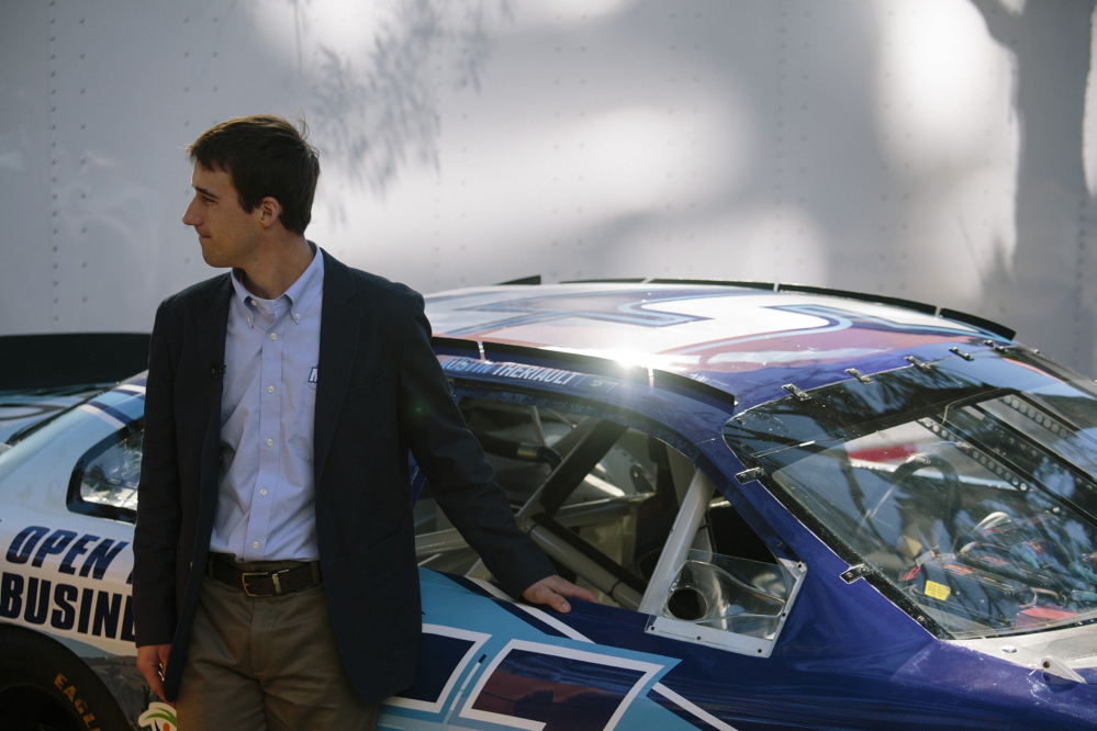 Austin Theriault poses by his Maine-branded race car following a press conference in Portland last September.