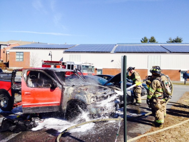 Waterville firefighters hose down a pick-up truck that burst into flames shortly after a Thomas College student parked it in a school parking lot Thursday morning.