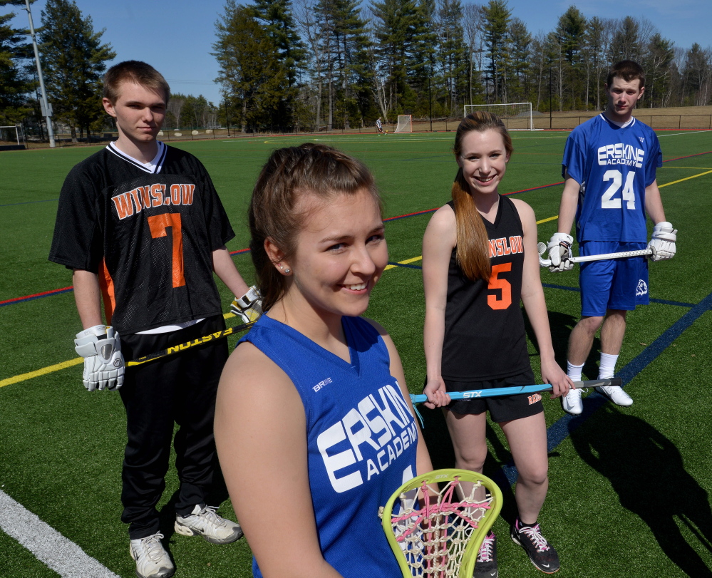 Erskine’s Kiley Drummond, foreground, stands with Winslow High School’s Jimmy Fowler, back left, Cassidy Roderick, back center, and Erskine classmate Trever Browne, back right, at Thomas College in Waterville on Thursday. Erskine and Winslow will field varsity girls and boys lacrosse teams for the first time this spring.