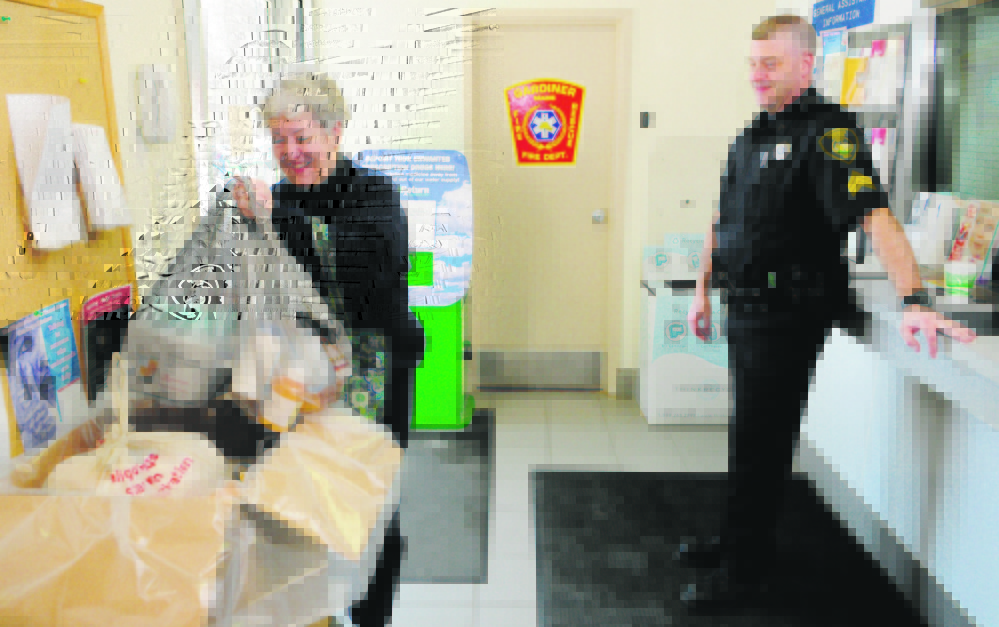 Carmen McCurdy, left, chats with Gardiner Police Sgt. Todd Pillsbury as she drops of medicine during the annual drug take-back at the Gardiner police station in 2013. Sheriff departments across Maine are helping take over the event after the national Drug Enforcement Agency said it can no longer afford to do it.