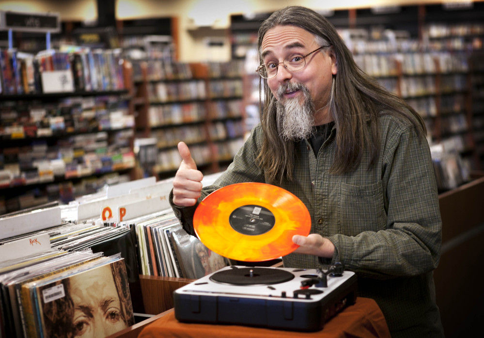 Chris Bown poses in Scarborough with a copy of The Knack’s “Live in Los Angeles 1978.”  Brown from Maine-based Bull Moose music hatched the idea for the annual event to celebrate local record stores, and the first one was held seven years ago.