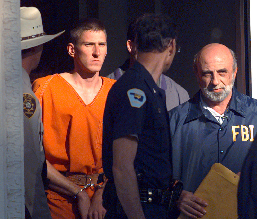 In this April 21, 1995 file photo, Timothy James McVeigh is lead out of the Noble County Courthouse by state and federal law enforcement officials in Perry, Okla., after being identified as a suspect in the bombing of the Oklahoma City Federal building.