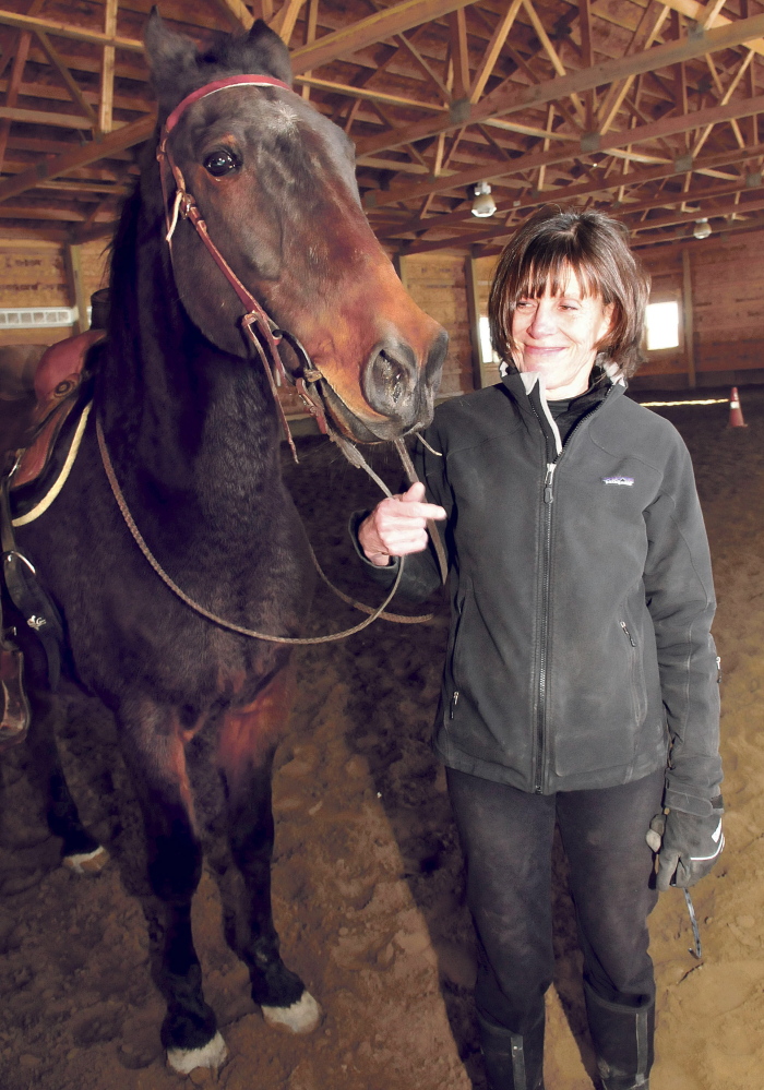 Debbie Hight stands with Postcard Jack, who has retired from harness racing and is training to be a saddle horse, on March 31.