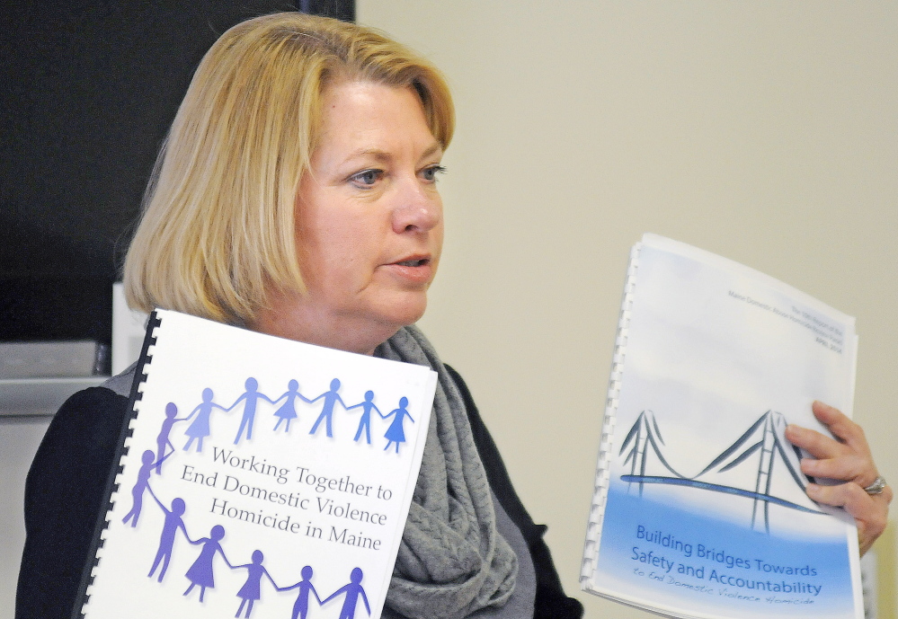 Deputy Attorney General Lisa Marchese Sunday displays two copies of the Maine Domestic Abuse Homicide Review Panel while addressing guests at the annual meeting of he Maine Chapter of Parents of Murdered Children in Augusta.