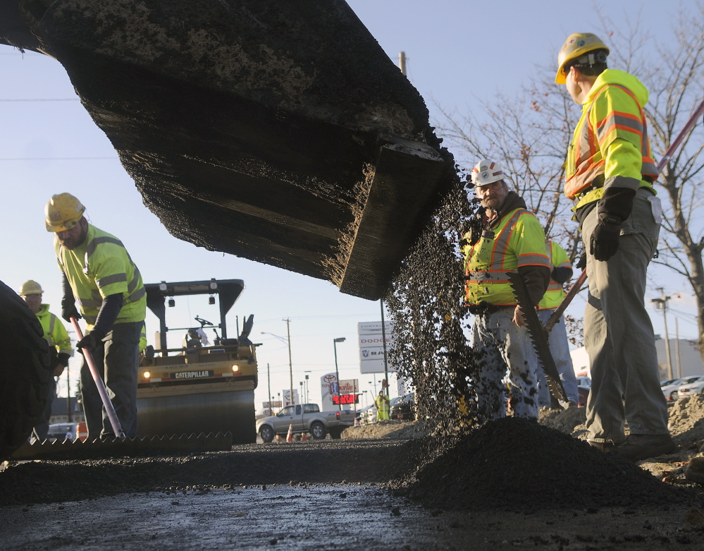 Pike Industries and Maine Department of Transportation employees pave Western Avenue in Augusta last October. Work will begin again Tuesday on that section of road.