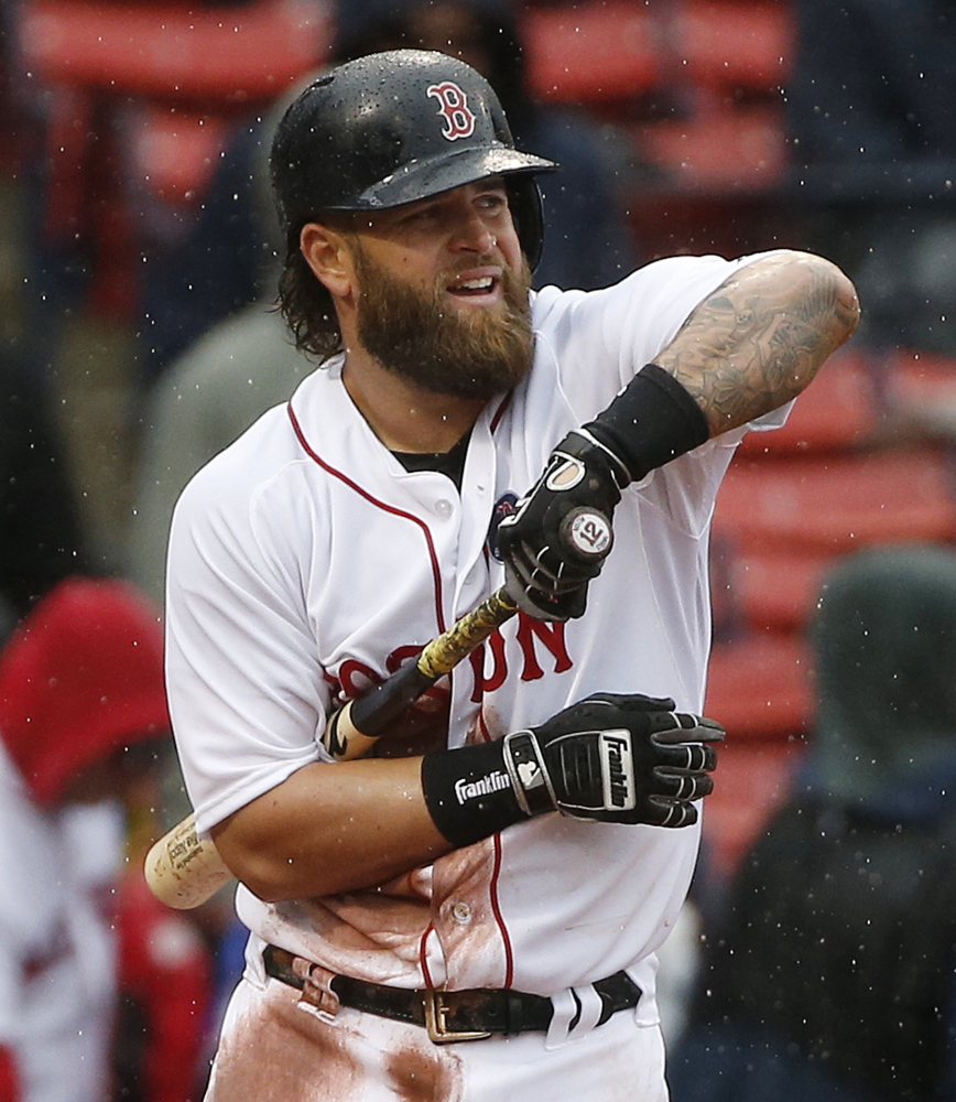 Boston Red Sox’s Mike Napoli dries his bat during the sixth inning of a baseball game against the Baltimore Orioles in Boston.