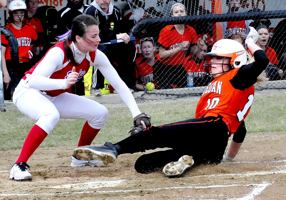 Messalonskee pitcher Kirsten Pelletier, left, covers home plate as Skowhegan’s Eliza Bedard makes it safe during a game on Wednesday.