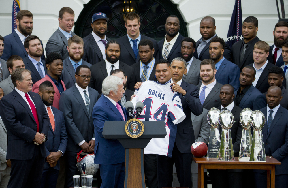 President Barack Obama holds a New England Patriots football jersey presented to him by New England Patriots owner Robert Kraft, during a ceremony on the South Lawn of the White House in Washington Thursday, where he honored the Super Bowl Champion New England Patriots for their Super Bowl XLIX victory.