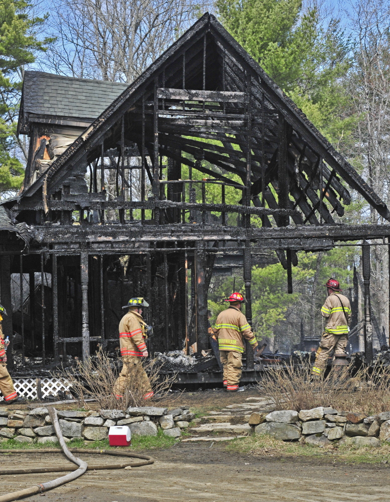 Firefighters survey the damage Friday after extinguishing a house fire at 131 Hunter Road in Dresden.
