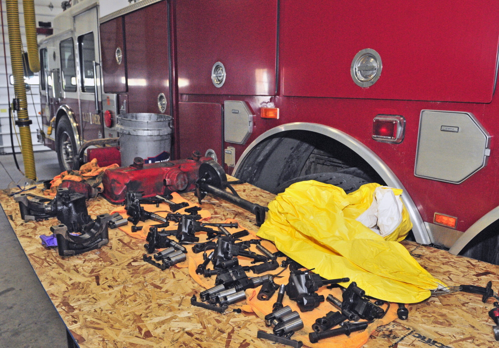 Engine parts are piled on a table Friday beside Augusta Fire Department’s disabled ladder truck, which is parked in the Western Avenue station.
