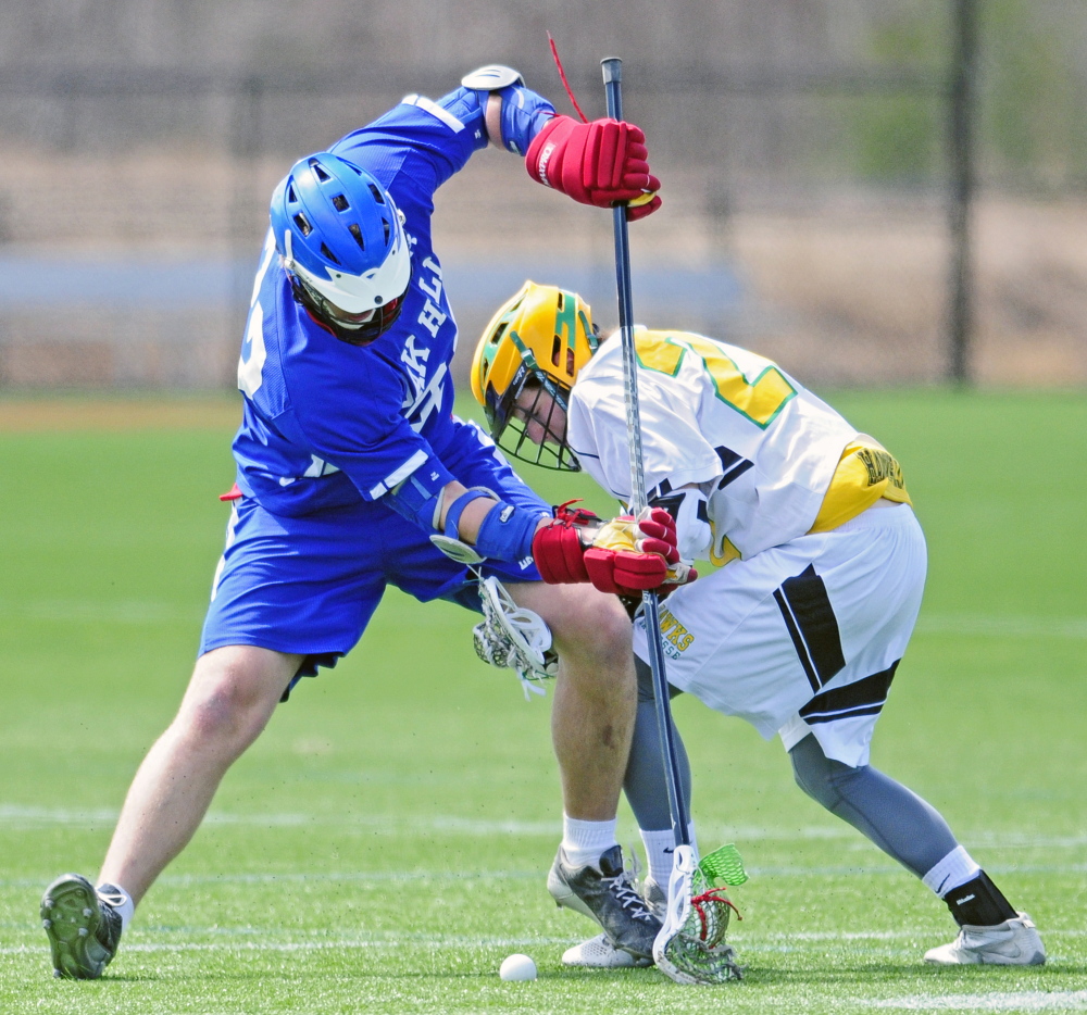 Oak Hill’s Kyle Field, left, and Maranacook’s James Canwell tangle for a loose ball during a game Friday afternoon at kents Hill. The Hawks cruised to a 20-1 victory.