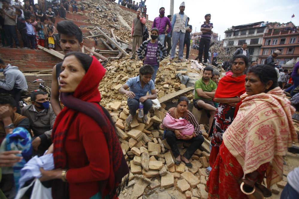 People rest on debris at Durbar Square after an earthquake in Kathmandu, Nepal, on Saturday.