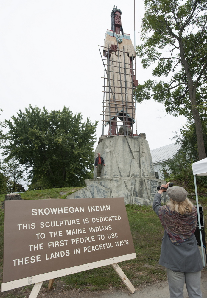 Judy Winterling, of Canaan, photographs her son Joschka as he stands with the newly refurbished Skowhegan Indian sculpture in September 2014 before a rededication for the 62-foot tall wooden piece created by Bernard Langlais in 1969. Some historians claim the name “Skowhegan” means “a place to watch,” while Roger Paul, a Passamoquoddy Indian language teacher says it means brook trout fishing weir.