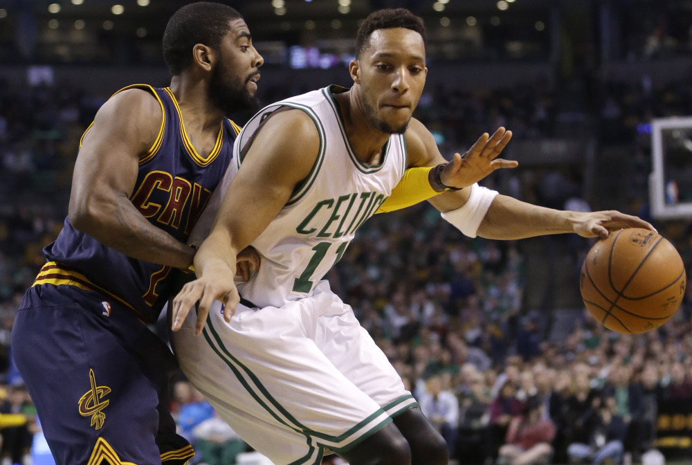 Kyrie Irving, left, of the Cavs puts pressure on Boston’s Evan Turner in Sunday’s playoff game at Boston.