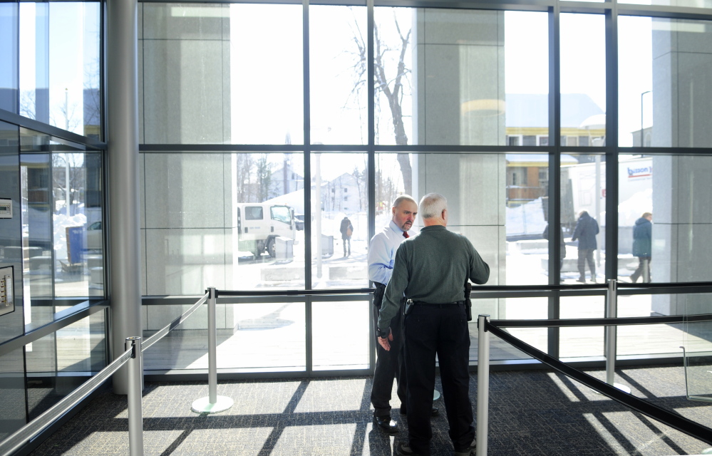 Michael A. Coty, director of judicial marshals, left, speaks with court officer Robert Annese in February while setting up security for the Capital Judicial Center in Augusta.