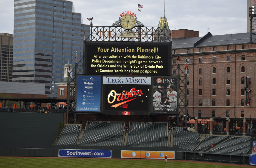 The scoreboard announces that the baseball game between the Baltimore Orioles and the Chicago White Sox is postponed, at Oriole Park at Camden Yards, Monday, in Baltimore.