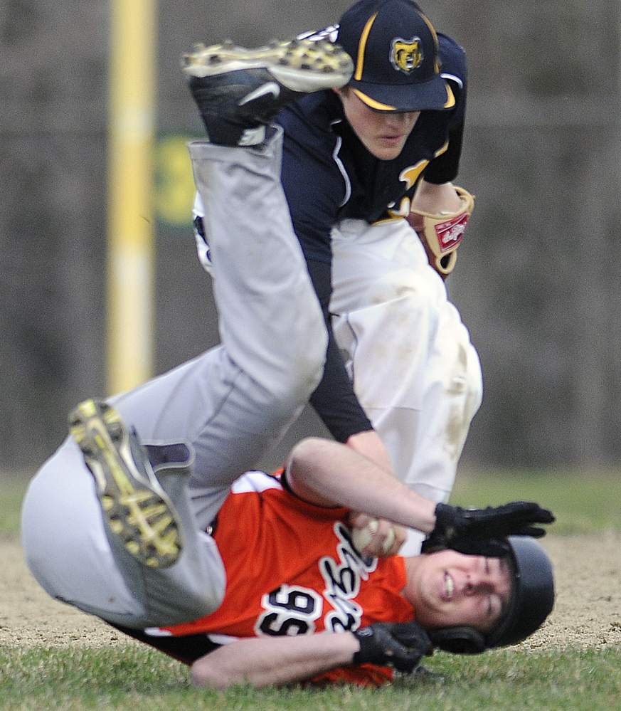 Gardiner’s Logan Peacock attempts to elude a tag by Maranacook’s Silas Mohlar after a run down between second and third bases Tuesday in Gardiner.