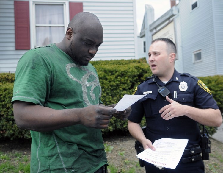 Augusta Police Officer Jesse Brann speaks with Water Street resident Breon Shannon Wednesday while handing out fliers to notify people of a larger police presence planned for the future. Shannon said he sees a lot of drug-related crime in the neighborhood. Police spread out across Augusta to hand out the information while soliciting input on how to combat crime.