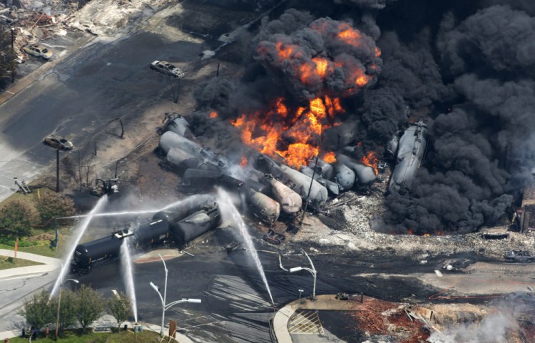 Smoke rises from railway cars carrying crude oil that derailed in downtown Lac-Megantic, Quebec, in July 2013. 2013 Associated Press File Photo