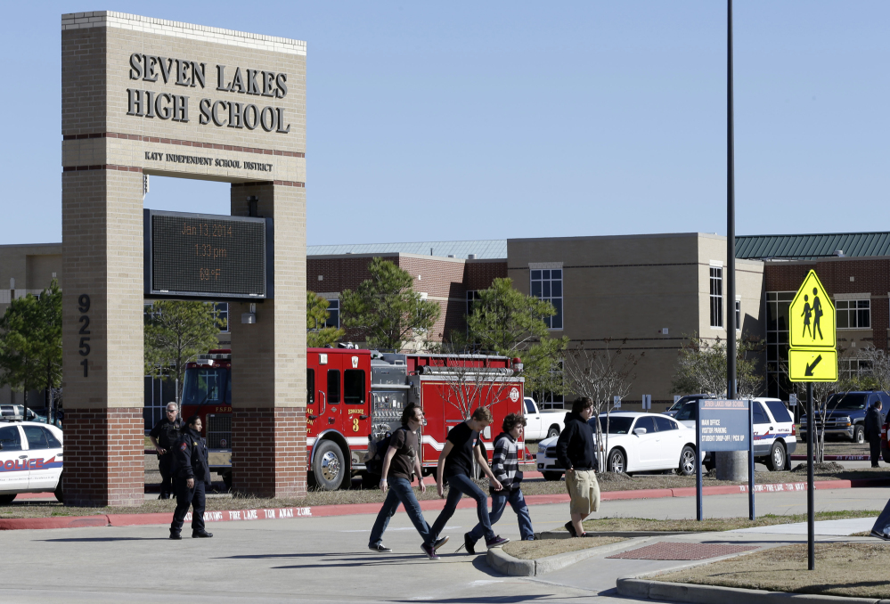 Students pass by Seven Lakes High School in Katy, Texas, after being evacuated and released from school for the day after a bomb squad was called to the school after a potentially explosive device was found.